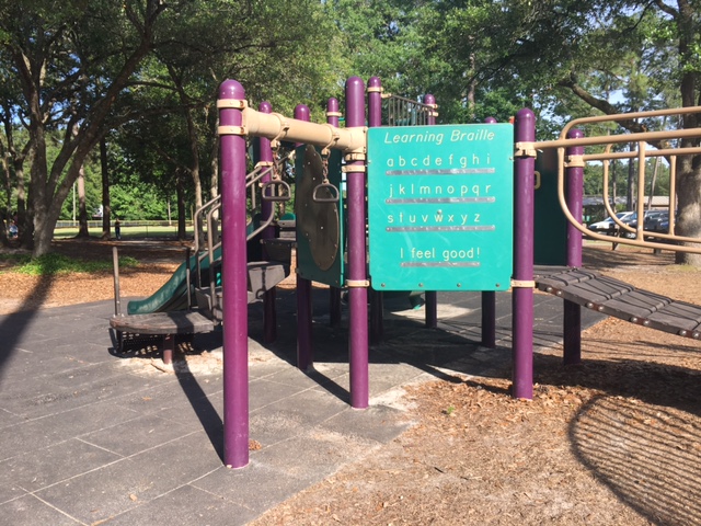 A piece of playground equipment with a braille learning display on it